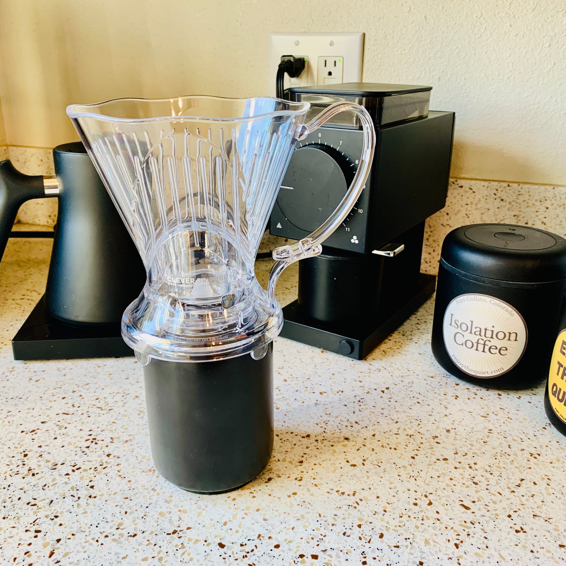Clever coffee dripper on a mug with coffee gear in the background